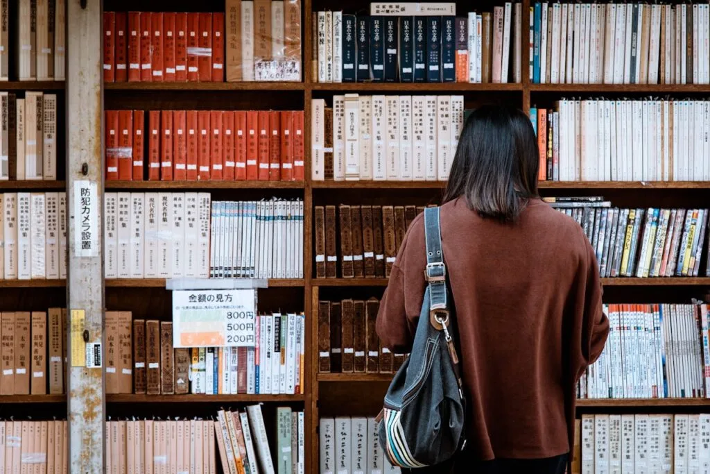 pexels-photo-1106468 Woman browsing books at a library in Nagano, Japan. Explore knowledge and literature.